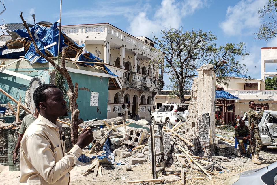 A man passes in front of the rubbles of the popular Medina hotel of Kismayo on July 13, 2019, a day after dozens were killed and over 50 people injured in a suicide bomb and gun attack claimed by Al-Shabaab militants. (Photo: Stringer/AFP/Getty Images)