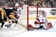 Pittsburgh Penguins' Evan Rodrigues (9) attempts a wrap-around shot from behind Carolina Hurricanes goaltender Antti Raanta (32) with Ethan Bear (25) defending during the second period of an NHL hockey game in Pittsburgh, Sunday, March 13, 2022. After review the shot was ruled no goal. (AP Photo/Gene J. Puskar)