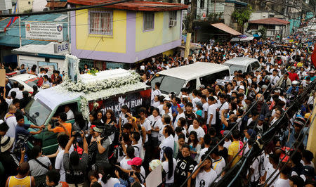 The flower-decked hearse of Kian delos Santos, a 17-year-old student who was shot during anti-drug operations, stops in front of a police station during the funeral march in Caloocan, Metro Manila, Philippines August 26, 2017. REUTERS/Erik De Castro