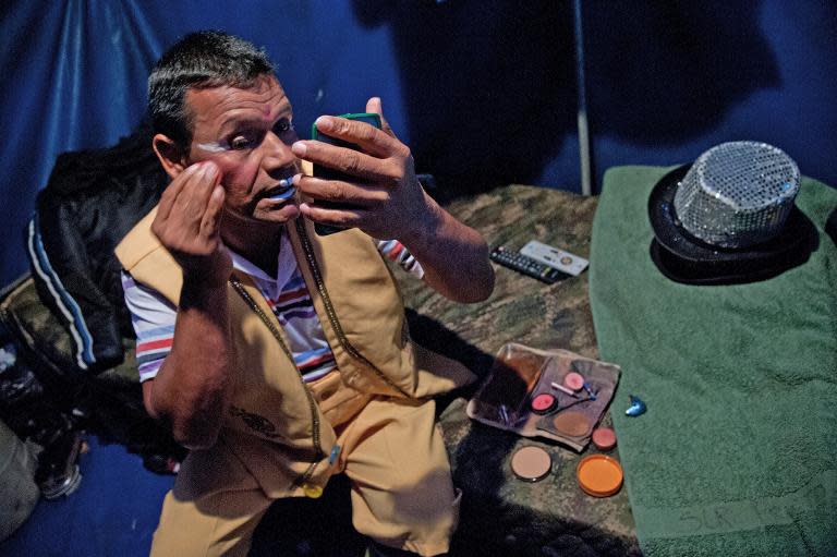 Clown Cascabelin (Soldier Daniel Borja) does his make-up before performance in the show of the Army's Colombia Circus in Tibirita, Cundinamarca department, on March 8, 2014