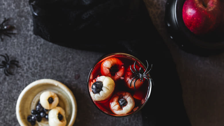 Overhead view of sangria pitcher with spider alongside sangria eyeballs