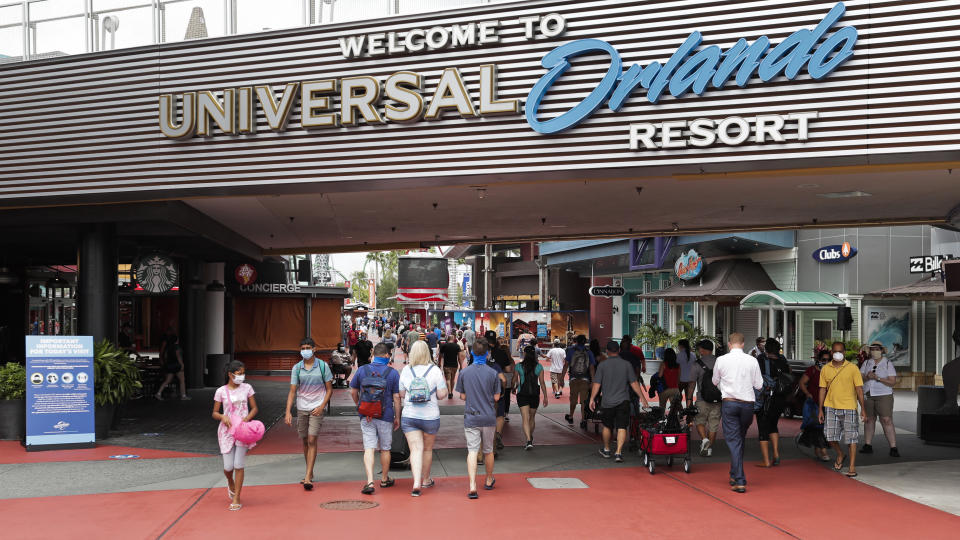 En esta foto del miércoles 3 de junio de 2020, visitantes llegan a Universal Studios en Orlando, Florida. El parque temático reabrió sus puertas para aquellas personas con pases de temporada y abrirá al público general el viernes. (AP Foto/John Raoux)