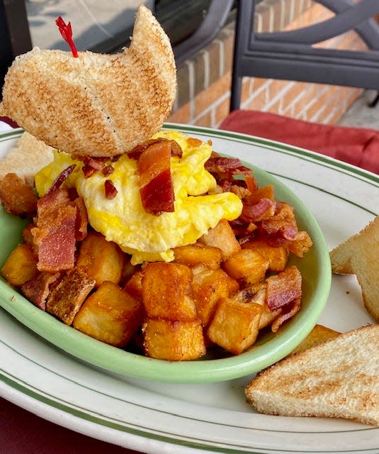Bada Bean's breakfast lineup includes this plate called "Bird Shot." with scrambled eggs over home fries covered with Hollandaise sauce, chopped bacon and toast.