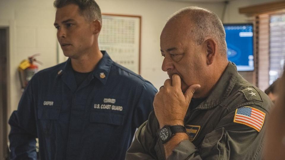 Petty Officer 1st Class Matthew Casper, left, advises Rear Adm. Michael Day about rescue operations during the 2023 wildfires in Maui. (Petty Officer 2nd Class Tyler Robertson/Coast Guard)