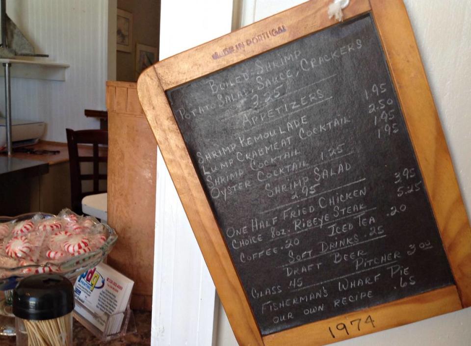 MARY PEREZ/SUN HERALD A hand-written Fisherman’s Wharf menu from 1974 hangs in the new restaurant now open on Lemoyne Boulevard in the D’Iberville-St. Martin area. Some of the same family recipes are used at the new restaurant, including the famous Wharf Pie.