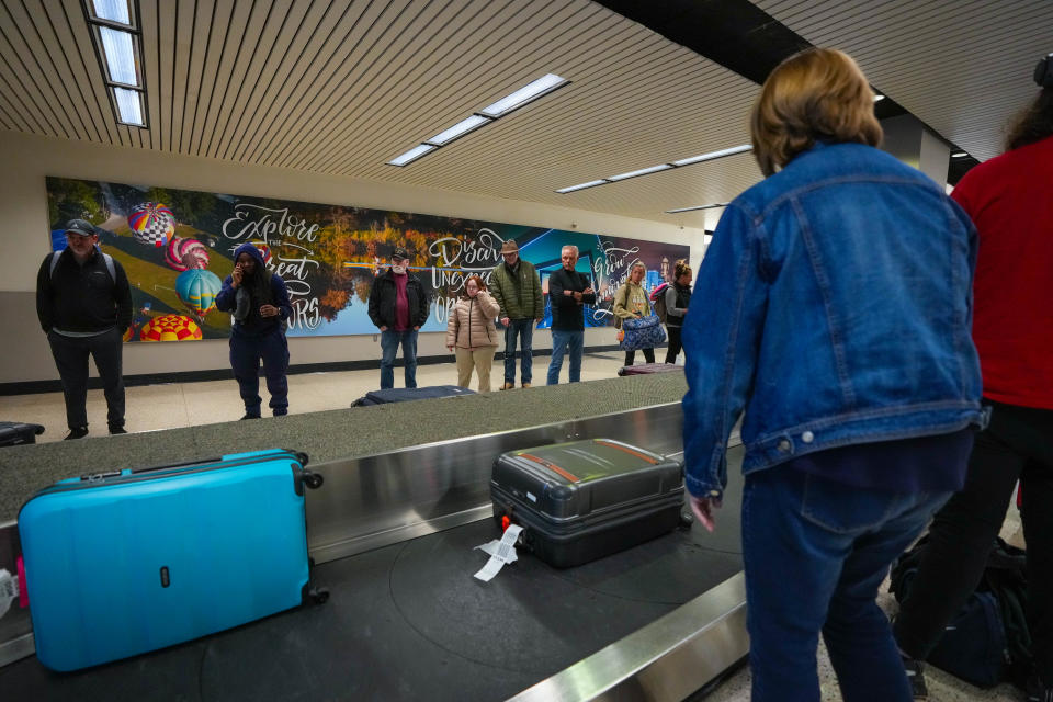 Travelers wait for their luggage at Des Moines International Airprt on Monday.