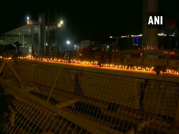 Protestesting farmers lighten up candles on barricades placed by security forces at Tikri border. (Photo/ANI)