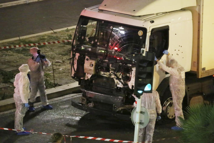 FILE - In this July 14, 2016 file photo, authorities investigate a truck after it plowed through Bastille Day revelers in the French resort city of Nice, France, killing 86 people. Eight people go on trial Monday Sept.5, 2022 in a special French terrorism court for alleged roles in helping the attacker who drove a truck into the Nice beachfront on Bastille Day 2016, killing 86 people. (Sasha Goldsmith via AP, File)