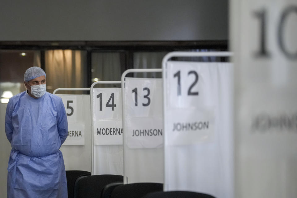 A medical staff member walks by vaccination booths in Bucharest, Romania, Friday, Oct. 22, 2021 as the country started a "vaccination marathon" with several centers open non stop for the next 72 hours, hoping to energize the failed vaccination campaign. In Romania, a European Union country of around 19 million, only 35% of adults are fully inoculated against COVID-19 compared to an EU average of 74%.(AP Photo/Vadim Ghirda)