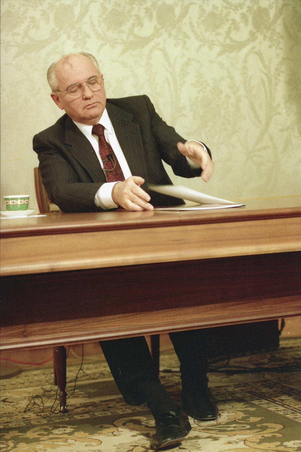 FILE - Mikhail Gorbachev, eighth and final leader of the Soviet Union, closes his resignation speech on the table after delivering it on Soviet television in the Kremlin, Moscow, Wednesday, Dec. 25, 1991, drawing a line under more than 74 years of Soviet history. Shortly thereafter, the Soviet hammer-and-sickle flag was lowered from the Kremlin, and in its place rose the white, blue, and red flag of Russia. (AP Photo/Liu Heung Shing, File)