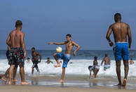 Beachgoers play with a soccer ball along the shore of Ipanema Beach amid the new coronavirus pandemic in Rio de Janeiro, Brazil, Sunday, Sept.6, 2020. Brazilians are packing the beaches and bars this weekend, taking advantage of a long holiday to indulge in normal life even as the COVID-19 pandemic rages on. (AP Photo/Bruna Prado)