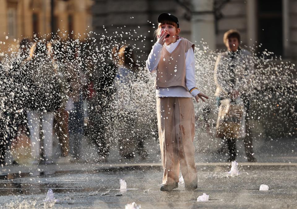 Children and adults play in a fountain in a square of Lviv Oblast in western Ukraine on Friday, May 5, 2023. | Scott G Winterton, Deseret News