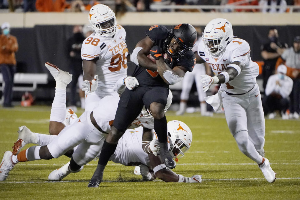 Texas defensive back Chris Adimora (1) moves in to tackle Oklahoma State running back LD Brown (0) in overtime of an NCAA college football game in Stillwater, Okla., Saturday, Oct. 31, 2020. (AP Photo/Sue Ogrocki)