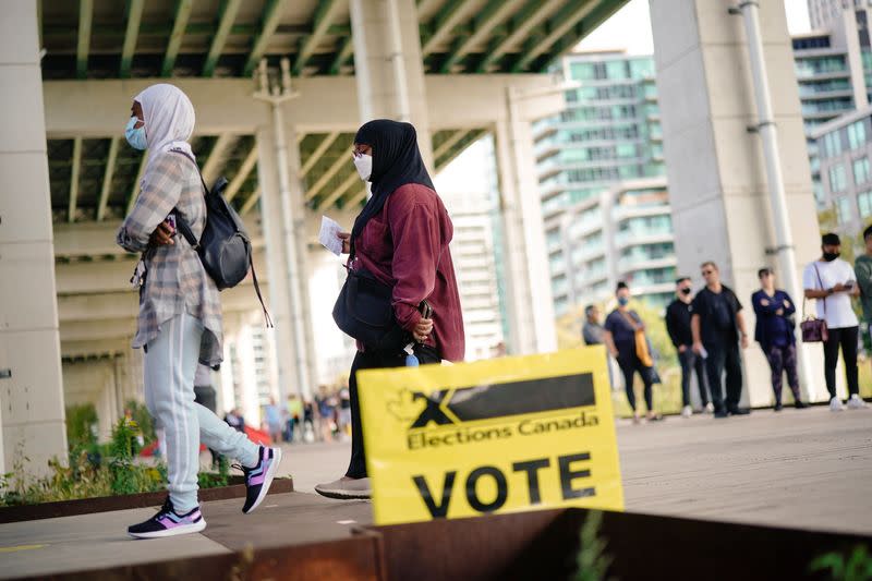 People line up outside a polling station to vote in Toronto