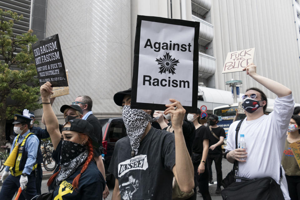 Demonstrierende tragen Mundschutze und Stofftücher über Mund und Nase und halten Schilder mit Aufschriften wie "Against Racism" oder "Fuck The Police" während eines Protests gegen Rassismus und Polizeigewalt. Foto: Rodrigo Reyes Marin / ZUMA Wire / dpa