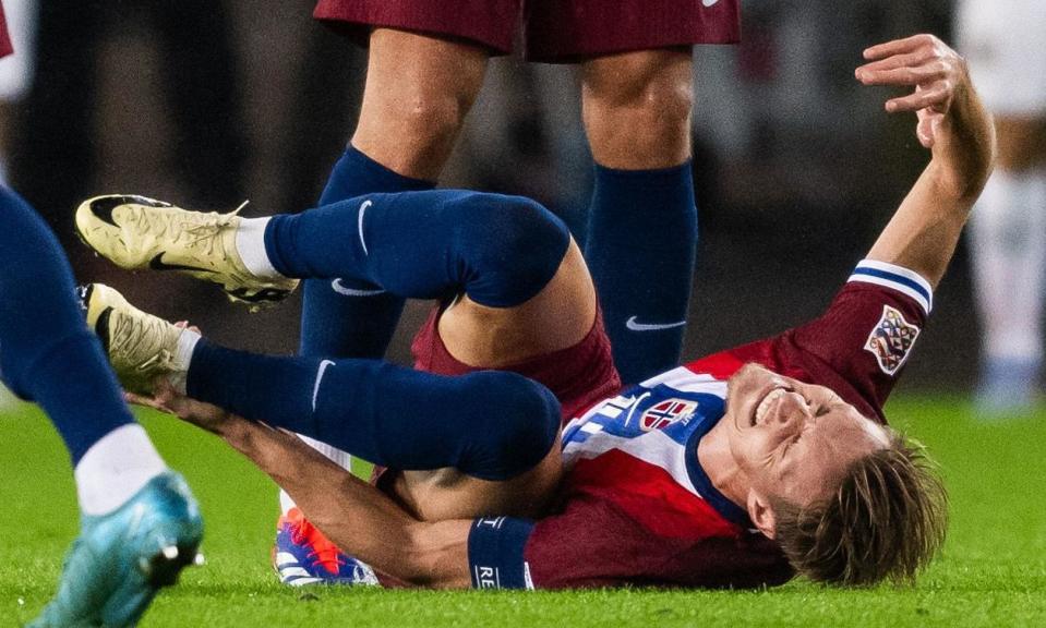 <span>Martin Ødegaard grabs his left ankle after going down injured against Austria.</span><span>Photograph: Marius Simensen/Bildbyrån/Shutterstock</span>