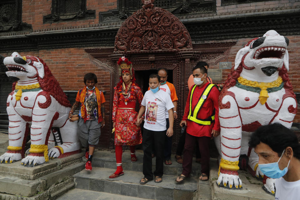 Living God Ganesh walks out from the residence of Living Goddess Kumari after performing rituals during Indrajatra festival as the festival was canceled to control the spread of the coronavirus in Kathmandu, Nepal, Sunday, Aug. 30, 2020. A lockdown was ordered around the eight days when the canceled Indrajatra festival would have been held, and instead, a small ceremony to seek forgiveness from Indra, the Hindu god of rain, was held under government security. Many in this Himalayan nation believe they would anger the gods by shunning the rituals — which would cause catastrophe. (AP Photo/Niranjan Shrestha)