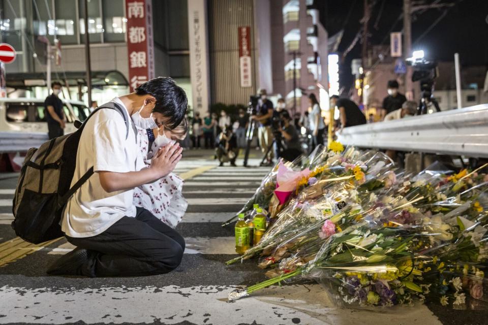 People pray at a site outside of Yamato-Saidaiji Station where Japan's former prime minister Shinzo Abe was shot