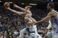 Sacramento Kings forward Domantas Sabonis, top, collides with Dallas Mavericks center Dwight Powell during the second half of an NBA basketball game in Sacramento, Calif., Friday, Feb. 10, 2023. The Mavericks won 122-114. (AP Photo/Randall Benton)