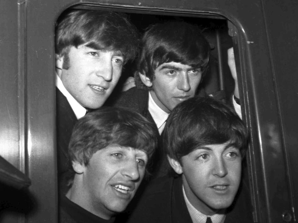 FILE - Britain's pop group The Beatles, clockwise from top left, John Lennon, George Harrison, Paul McCartney and Ringo Starr, pose in a carriage window of train before they left Paddington Station in London, March 2, 1964. The final Beatles recording featuring John, Paul, George and Ringo is here. Released Thursday and titled “Now and Then,” the song comes from a batch of unreleased demos written by the late John Lennon in the ’70s (AP Photo/Bob Dear, File)