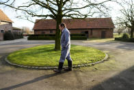 Bart Dochy walks toward a barn at his family farm in Ledegem, Belgium, Tuesday, Feb. 13, 2024. After dealing with hectacres of fields and barns full of animals Dochy just as handily steps into a three-piece suit to pick up his job as mayor of this farming community in Landegem. (AP Photo/Virginia Mayo)