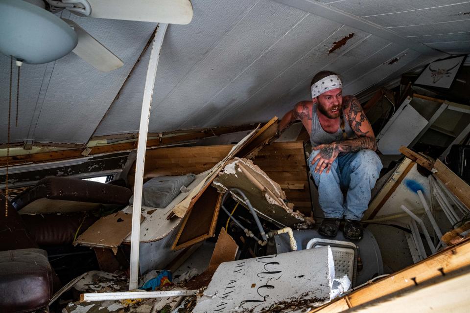 Blake Wagner searches though his destroyed home for any possessions that may be salvageable following Hurricane Ian on Oct. 2, 2022. 