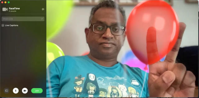 FaceTime screenshot of Engadget’s Devindra Hardawar giving a peace sign, which triggers a balloon effect transposed over his hand.