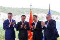 Greek Foreign Minister Nikos Kotzias, his Macedonian counterpart Nikola Dimitrov, Greek Prime Minister Alexis Tsipras and Macedonian Prime Minister Zoran Zaev applaud after signing an accord to settle a long dispute over the former Yugoslav republic's name as look on in the village of Psarades, in Prespes, Greece, June 17, 2018. REUTERS/Alkis Konstantinidis