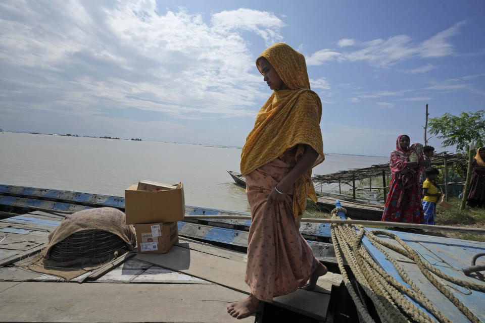 25-year-old Jahanara Khatoon, who is at full-term pregnancy, boards a boat on her way to a health centre, in Sandoh Khaiti Char, in the northeastern Indian state of Assam, Wednesday, July 3, 2024. (AP Photo/Anupam Nath)