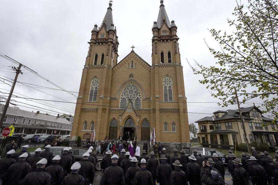 Members of the Massachusetts state police, below, line the street as mourners for the late U.S. Capitol Police officer William "Billy" Evans, depart St. Stanislaus Kostka Church following a funeral Mass, in Adams, Mass., Thursday, April 15, 2021. Evans, a member of the U.S. Capitol Police, was killed on Friday, April 2, when a driver slammed his car into a checkpoint he was guarding at the Capitol. (AP Photo/Steven Senne)