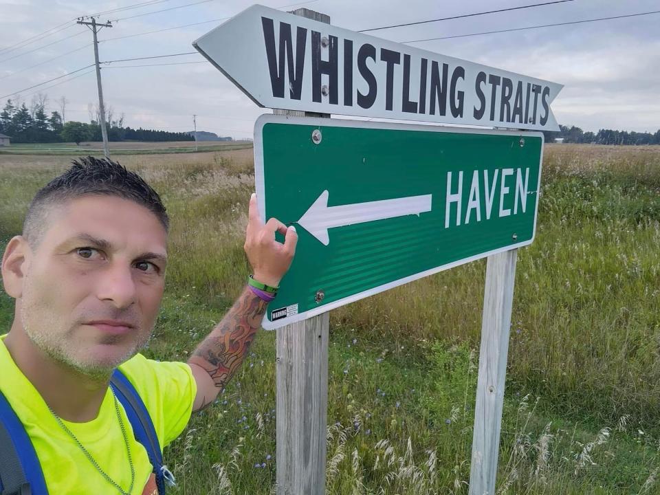 Cudahy resident Greg Studzinski walked away from addiction by walking 136 miles from Green Bay to Cudahy over five days in early September. Here he poses in front of the signs for Whistling Straits and Haven.