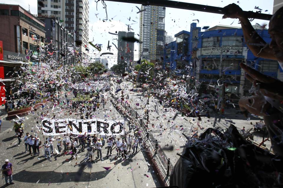 Supporters throw confetti at workers as they march for a rally near the Presidential Palace in Manila to celebrate international Labor Day known as May Day Tuesday May 1, 2012 in the Philippines. Thousands of workers marched under a brutal sun in Manila to demand a wage increase amid an onslaught of oil price increases, but the Philippine President rejected a $3 daily pay hike which the workers have been demanding since 1999 and warned may worsen inflation, spark layoffs and turn away foreign investors. (AP Photo/Bullit Marquez)