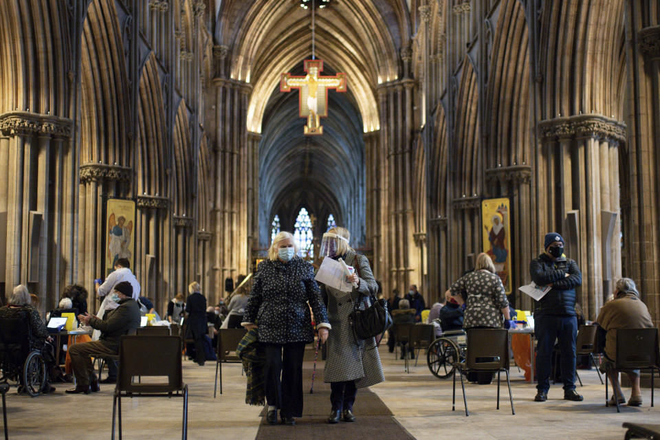 Audrey Elson, 84, leaves with her daughter after receiving a dose of the Oxford/AstraZeneca coronavirus vaccine at Lichfield Cathedral, in Staffordshire, England, Friday, Jan. 15, 2021. The U.K. is ramping up its mass vaccination program as the government seeks to protect the country’s oldest and most vulnerable residents before easing a third national lockdown. (Jacob King/PA via AP)