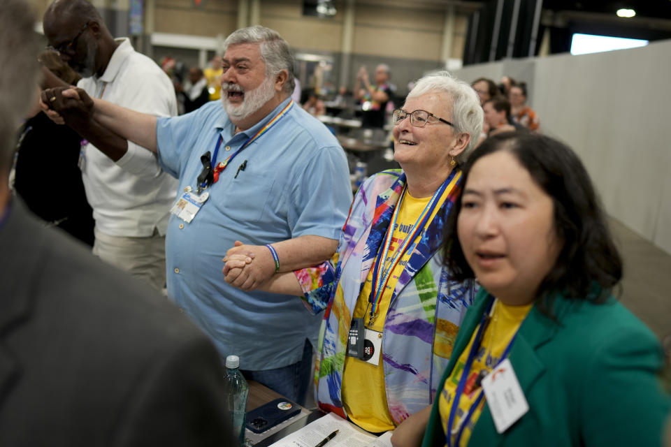 David Meredith, left, and Jan Lawrence react after an approval vote at the United Methodist Church General Conference Wednesday, May 1, 2024, in Charlotte, N.C. United Methodist delegates repealed their church’s longstanding ban on LGBTQ clergy with no debate on Wednesday, removing a rule forbidding “self-avowed practicing homosexuals” from being ordained or appointed as ministers. (AP Photo/Chris Carlson)