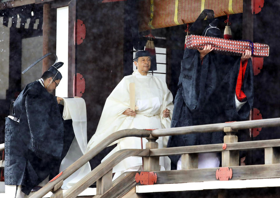 Japan's Emperor Naruhito, in a white robe, leaves after praying at “Kashikodokoro”, one of three shrines at the Imperial Palace, in Tokyo, Tuesday, Oct. 22, 2019. Emperor Naruhito visited three Shinto shrines at the Imperial Palace before proclaiming himself Japan’s 126th emperor in an enthronement ceremony. (Kyodo News via AP)