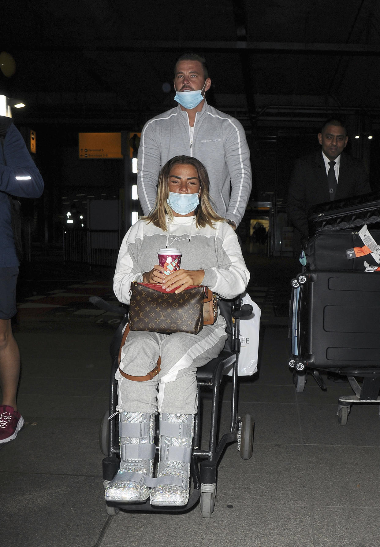 Photo by: zz/KGC-305/STAR MAX/IPx 2020 11/6/20 Katie Price and her boyfriend Carl Woods are seen on November 6, 2020 arriving at Heathrow Airport - returning to England from their holiday in The Maldives. They were not in compliance with strict government guidelines mandated during the worldwide coronavirus pandemic as they both were wearing their face masks improperly as both had their noses exposed. (London, England, UK)