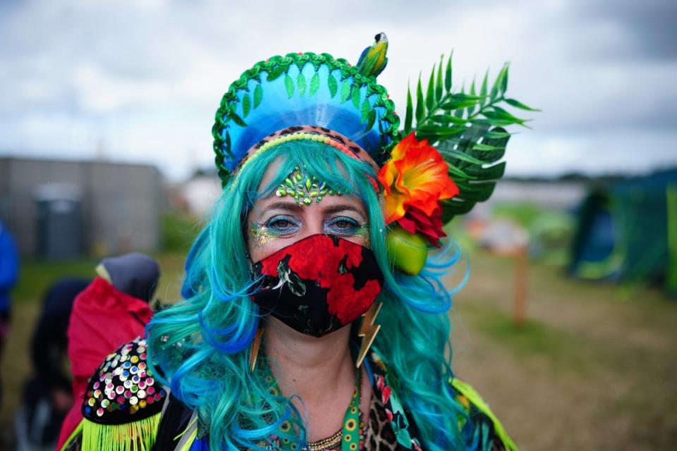 A festival-goer wearing a face mask as part of their elaborate outfit (Ben Birchall/PA) (PA Wire)