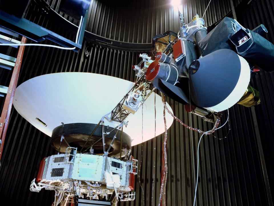 An image showing the Voyager evidence test model displayed in a space simulator room at JPL in 1976 was a replica of the twin Voyager space probes launched in 1977.