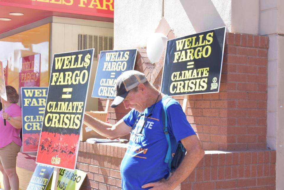 Richard Sigler protests Wells Fargo's financing of fossil fuel emissions outside a branch in downtown Tempe.