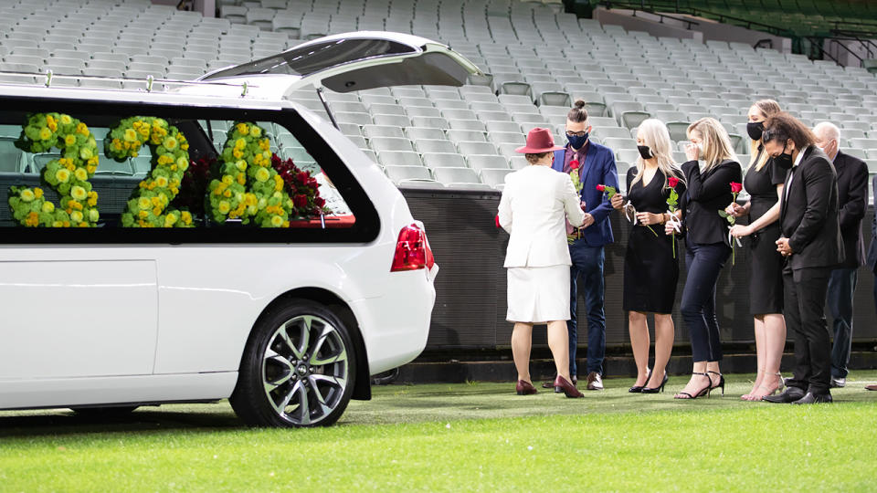 Family and mourners are pictured at the private memorial for Dean Jones.