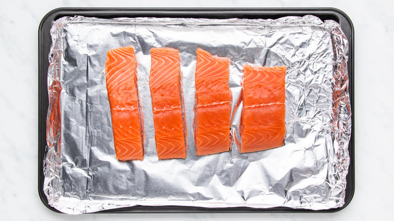 Salmon fillets on foil covered baking sheet