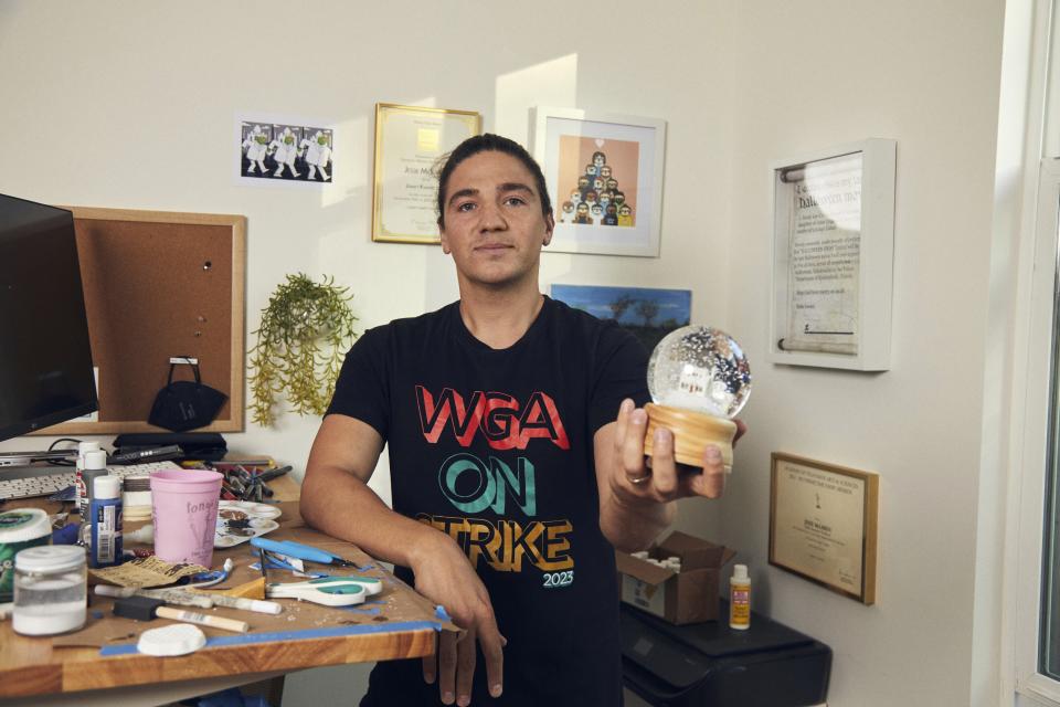 Jesse McLaren holds one of his custom-built snow globes in Los Angeles on Sept. 6, 2023. McLaren, who writes for “Jimmy Kimmel Live!” decided to monetize his hobby of making snow globes when members of the Writers Guild of America went on strike. (Matt Martin via AP)