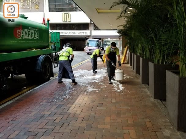 食環署員工在酒店大門外的麼地廣場行人路倒上清潔劑洗地。（任方攝）