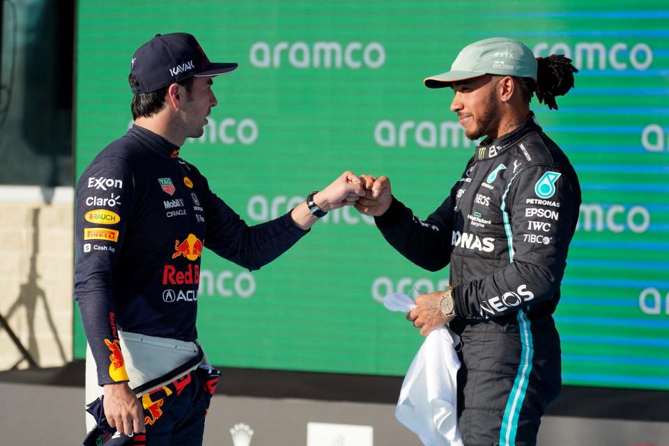 Red Bull driver Sergio Perez, left, of Mexico, and Mercedes driver Lewis Hamilton, of Britain, fist bump after qualifications for the Formula One U.S. Grand Prix auto race at the Circuit of the Americas