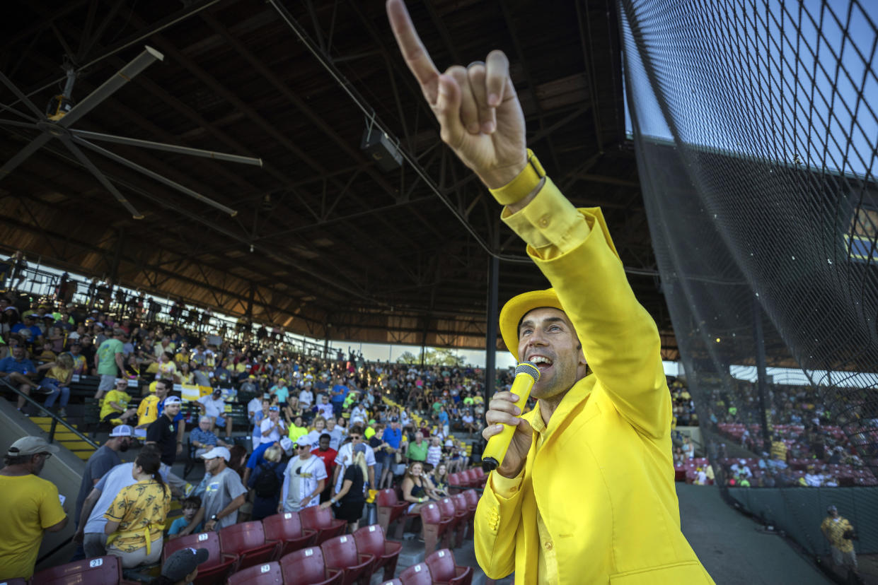 Savannah Bananas owner Jesse Cole emcees a performance with with the fans from on top of a dugout before a baseball game Tuesday, June 7, 2022, in Savannah, Ga. (AP Photo/Stephen B. Morton)