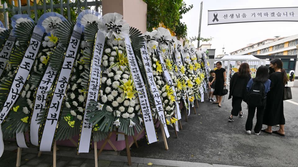 Mourners walk past funeral wreaths in front of the main gate of Seoul Seoi Elementary School in Seoul on September 4, 2023. - Jung Yeon-je/AFP/Getty Images