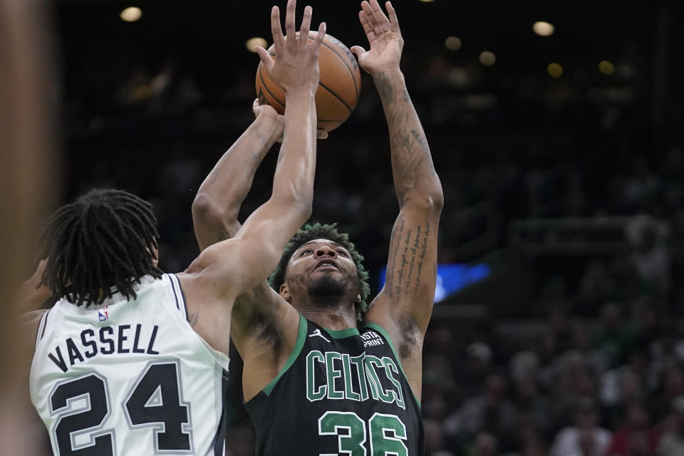 Boston Celtics guard Marcus Smart (36) takes a shot at the basket as San Antonio Spurs guard Devin Vassell (24) defends in the first half of an NBA basketball game, Sunday, March 26, 2023, in Boston. (AP Photo/Steven Senne)