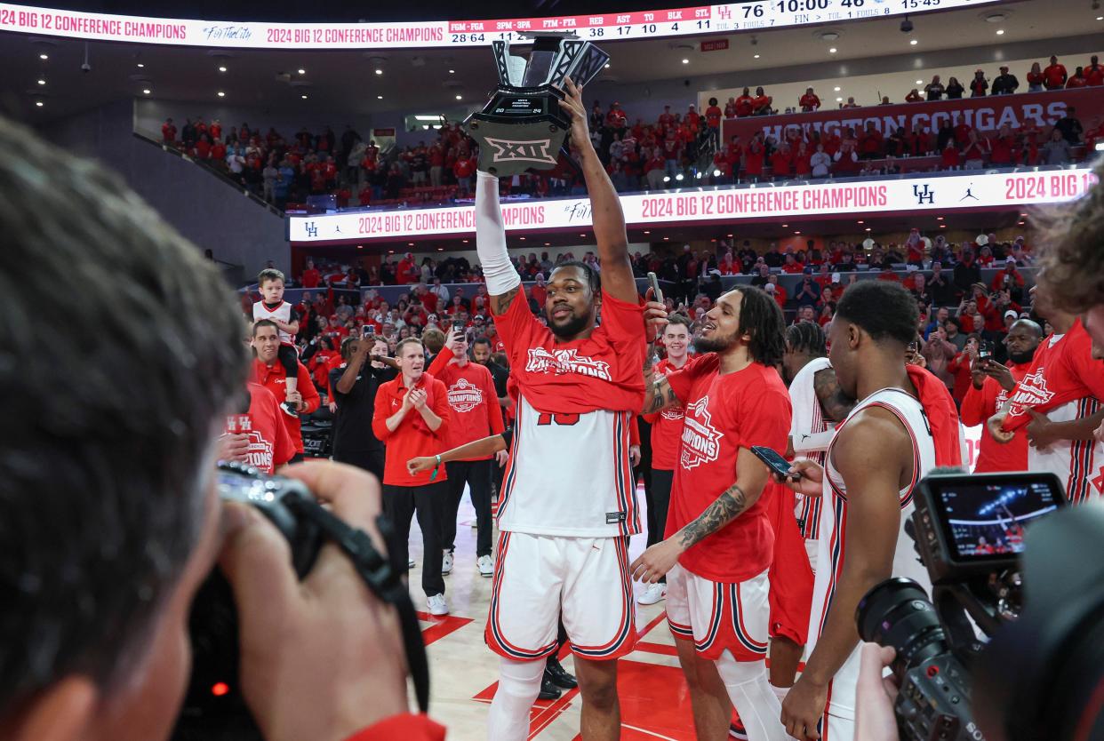 Houston forward J'Wan Roberts (13) holds the Big 12 conference championship trophy after a victory against Kansas.