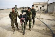 FILE - In this Friday, Nov. 22, 2013 file photo, Iraqi and Lebanese Shiite fighters from a group called the Hussein Brigade arrest a member of the Sunni-dominated Free Syrian Army in the town of Hatita, in the countryside of Damascus, Syria. As the Syrian conflict entered its forth year this month and large parts of the country are either destroyed or under opposition control, Syrian officials say the presidential elections will be held on time later this year. The opposition rejects such a move saying after the death of more than 140,000 people and millions turned to refugees or displaced, Assad should step down rather than run again. (AP Photo/Jaber al-Helo, File)