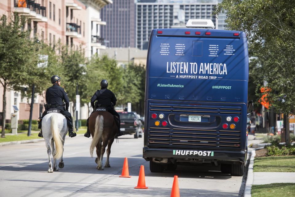 Police officers on horseback make their way around the HuffPost tour bus.